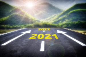 A road leading to a sunrise with an arrow from 2021 to 2022