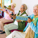 Four senior women stretch exercise bands to stay fit at an assisted living community